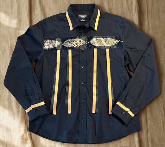 Black shirt with gold feather designs on a wooden surface