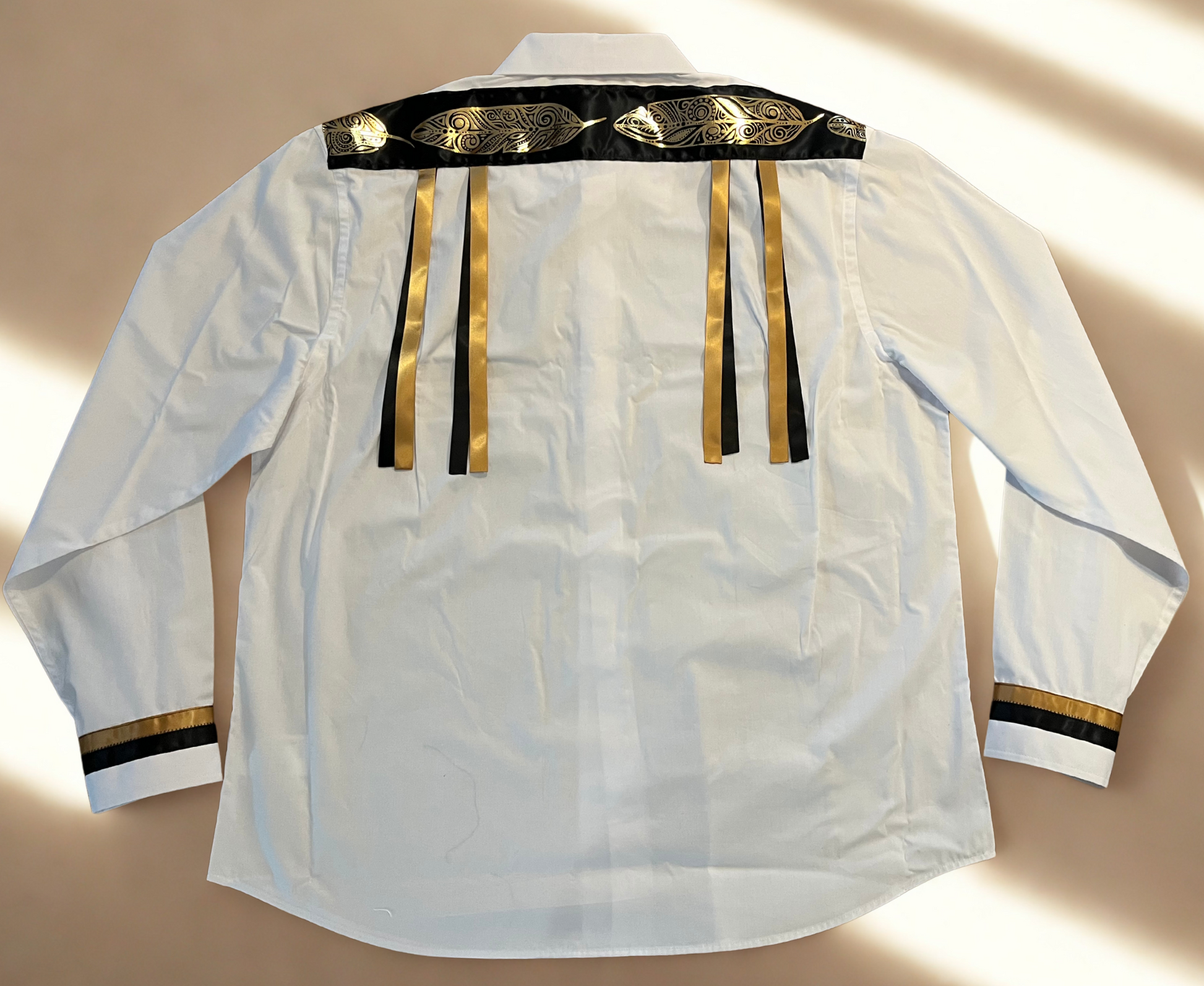 White shirt with gold and black accents on a beige background