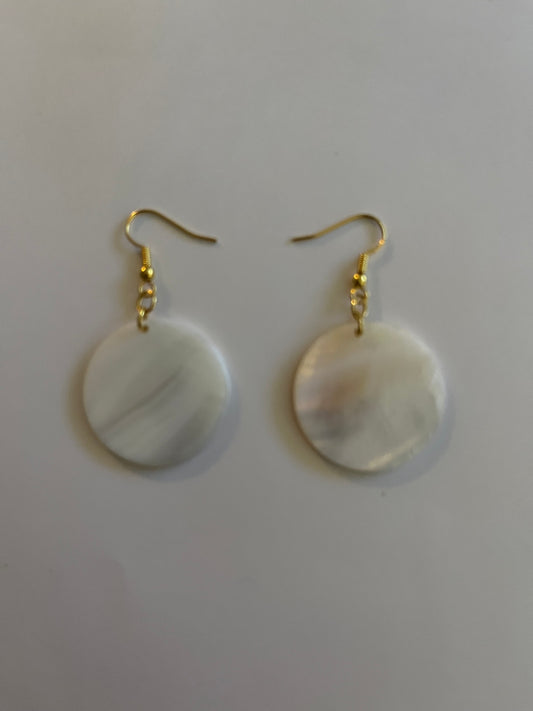Pair of earrings with gold hooks and round, white stones on a light gray background