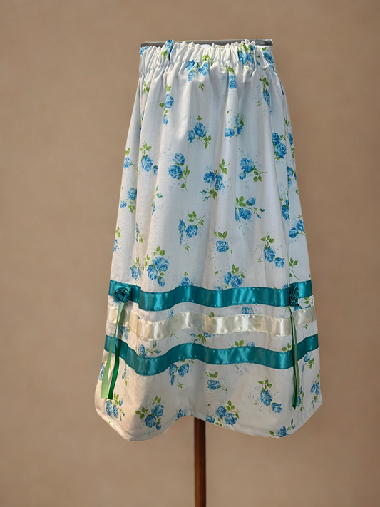 Floral apron with blue flowers and green leaves on a beige background