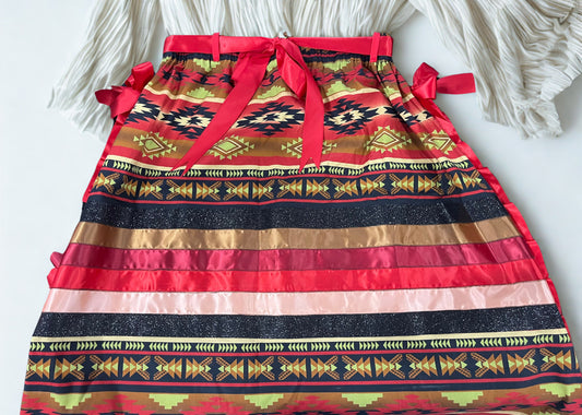 Colorful patterned skirt with red waistband and decorative bows on a white background