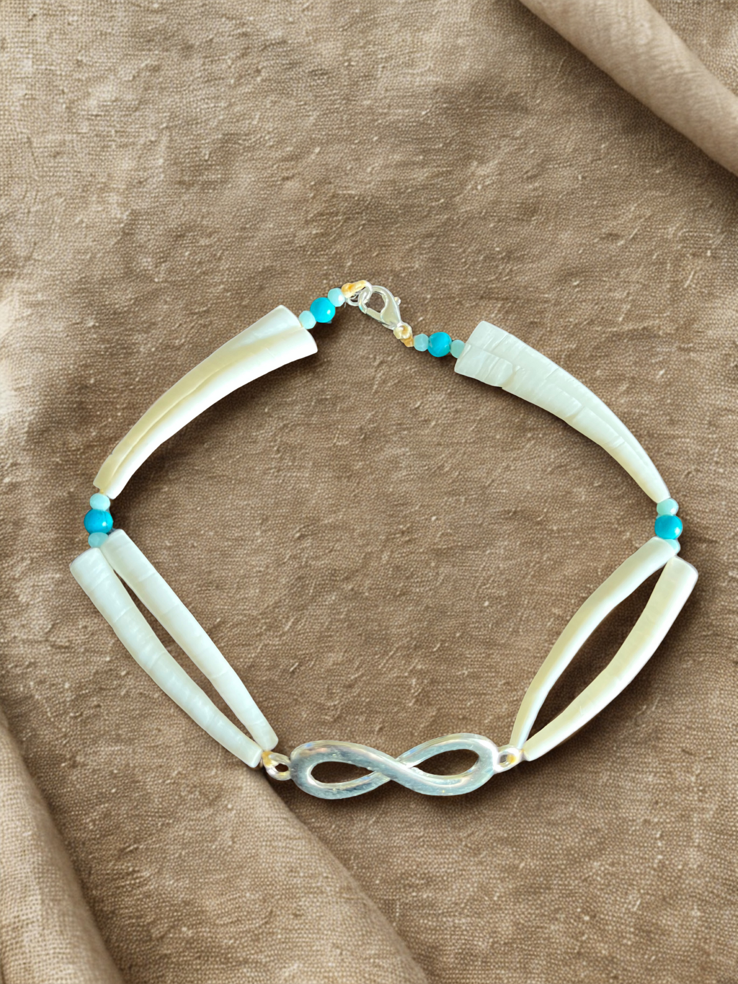 Bracelet with dentalium shells on a brown fabric background