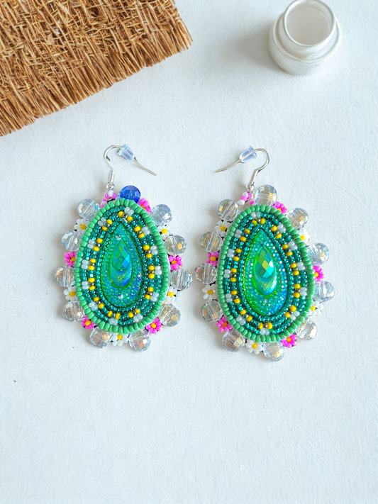 Pair of beaded earrings on a white surface with a neutral background