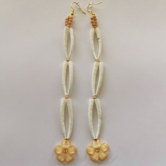 Pair of earrings with beige floral beads on a light gray background